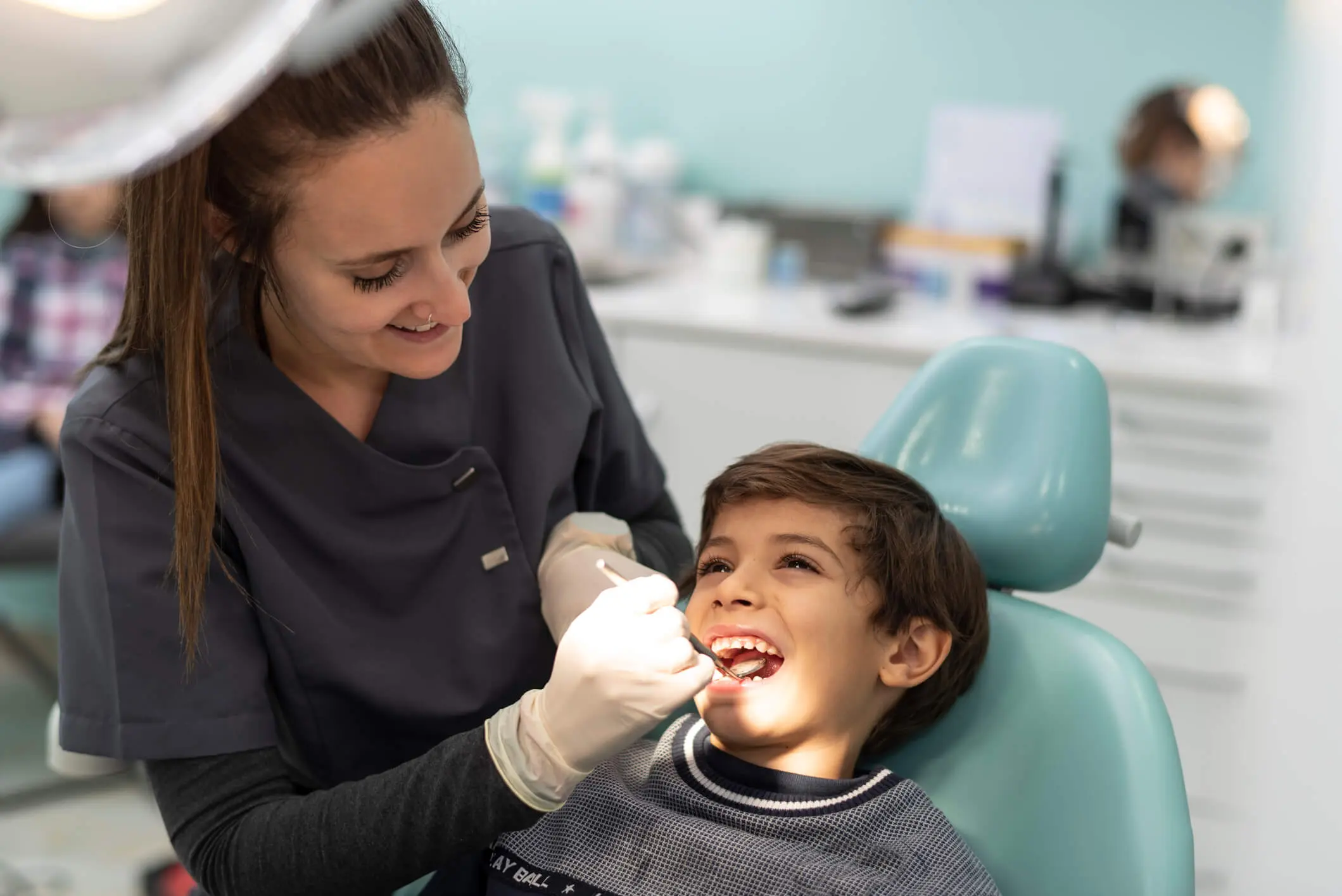 Dentist examining a smiling child's teeth.