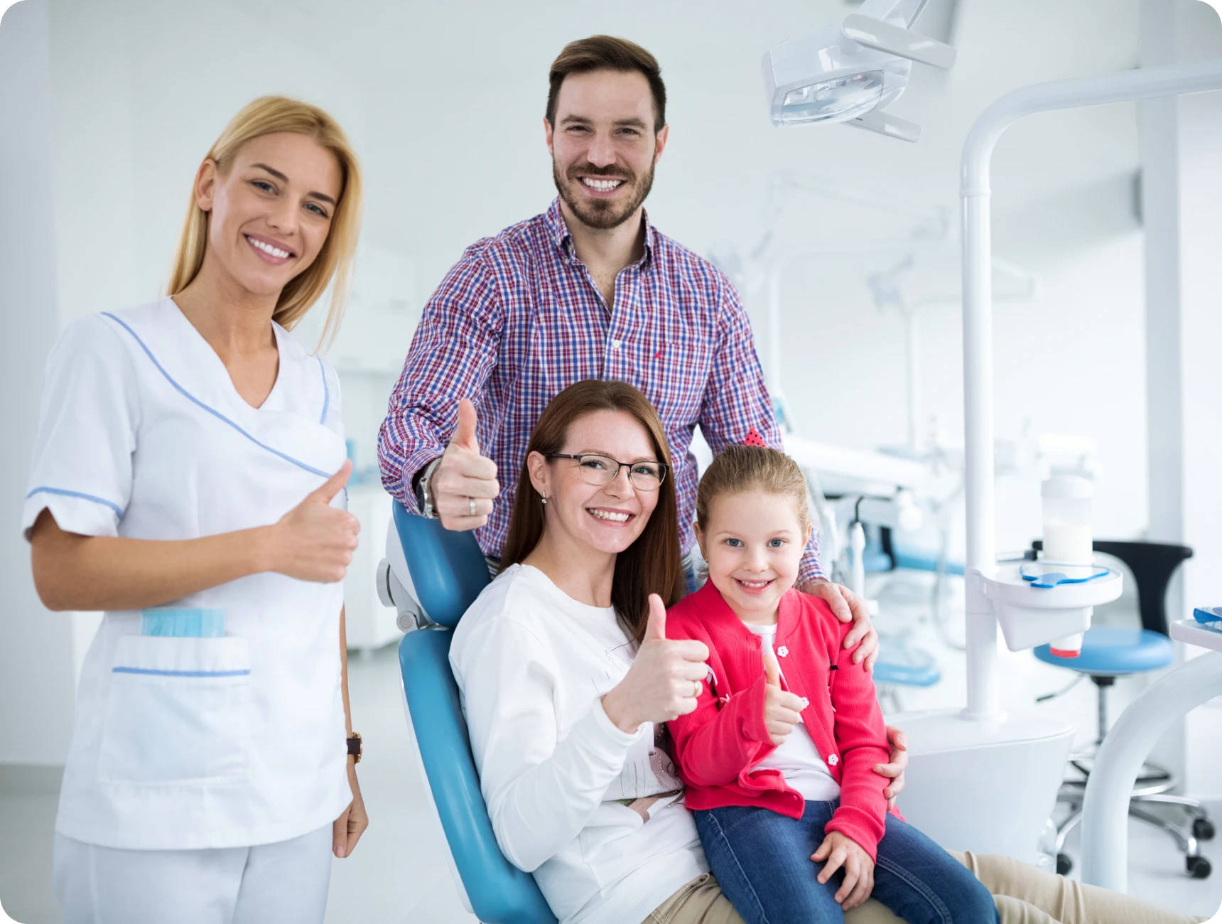 Dentist with happy family giving thumbs up