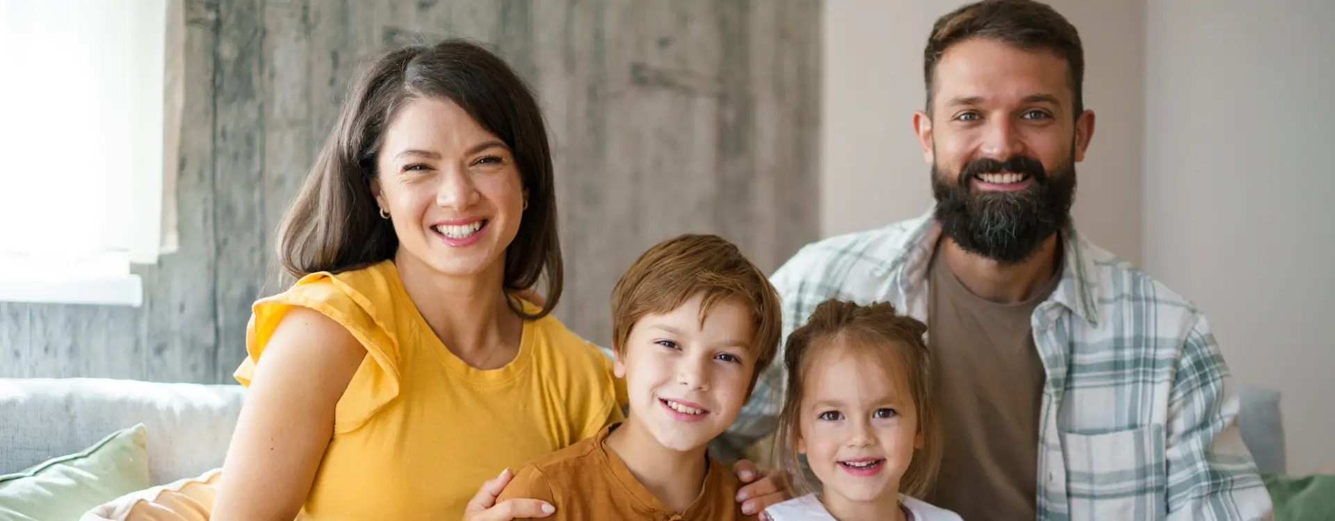 Smiling family sitting together in living room.